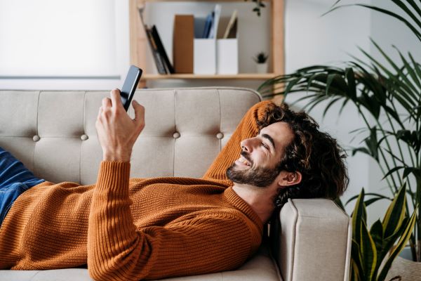 Muž na sedačce s mobilem hledá tipy na cesty