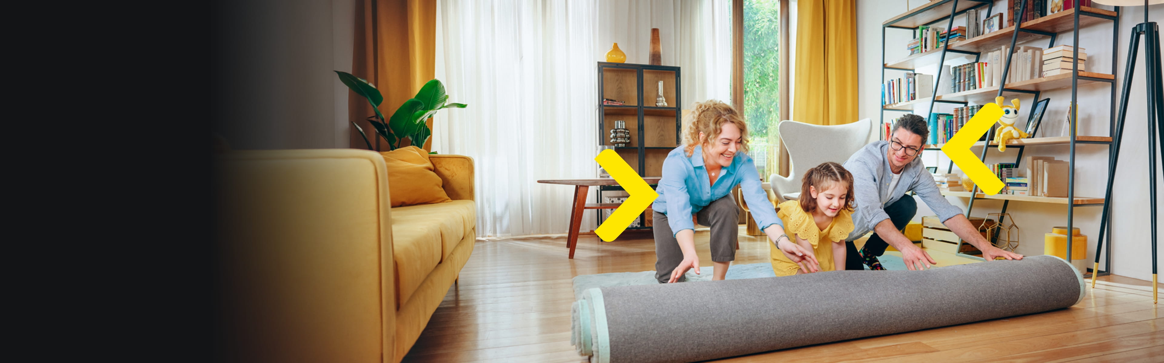 Rodina rozbaluje koberec v novém obývacím pokoji
